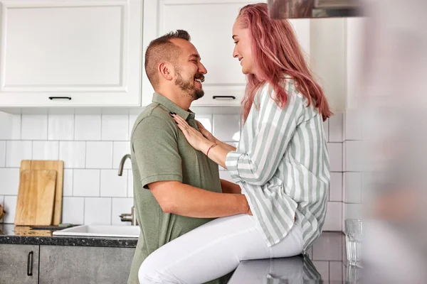 Afetuoso belo jovem casal abraçando beijando na moderna cozinha branca aconchegante — Fotografia de Stock