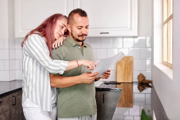 Prachtig Kaukasisch paar controleren facturen documenten in de keuken — Stockfoto