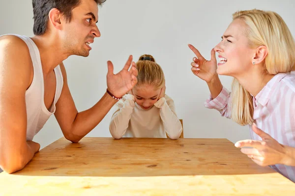 Gyermek lány ül hallgat szülei kiabálnak egymással — Stock Fotó