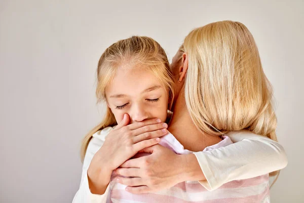 Portret van weinig Kaukasisch kind meisje kalmeren haar moeder — Stockfoto