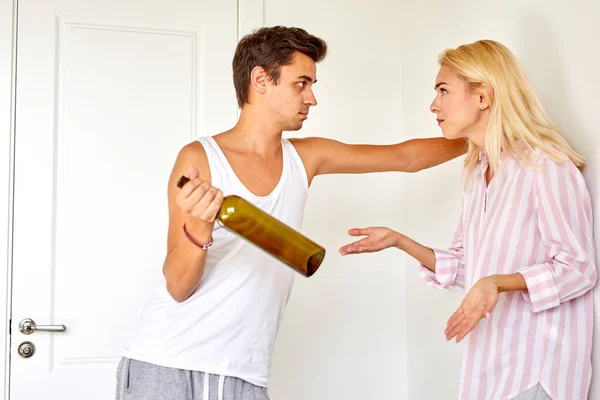 Женщина сердито кричит на своего пьяного мужа дома — стоковое фото