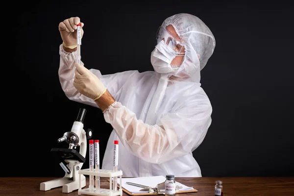 Científico masculino está probando una muestra de tubos biológicos contaminados por el virus Corona Covid 19 — Foto de Stock