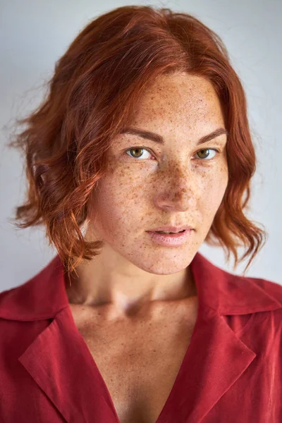 Zbliżenie portret piegowata kobieta z rudymi włosami patrząc w aparat — Zdjęcie stockowe