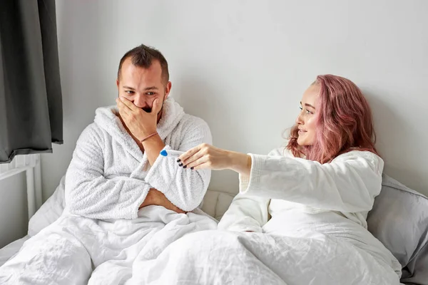 Heureux couple caucasien être excité avec positif test de grossesse sur le lit — Photo