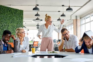Kaba, kızgın, patron kadın çalışanlardan rahatsız oluyor, çığlık atıyor.