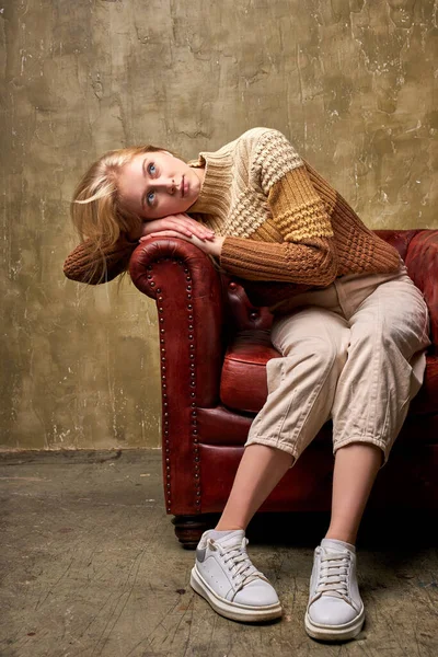 Ονειρική ξανθιά γυναίκα κάθεται ονειρεύεται στον καναπέ — Φωτογραφία Αρχείου