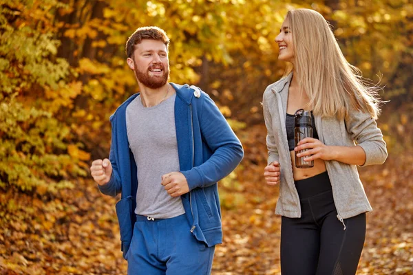 athletic caucasian couple enjoy running together in the forest