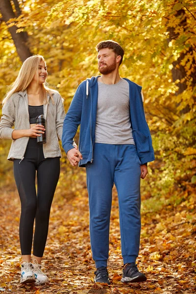 Lovely young couple enjoying walk in the autumn sunny forest — Stock Photo, Image