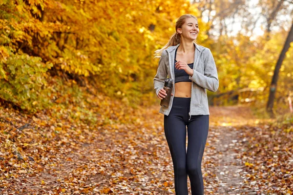 晴れた秋の日に走る運動選手の女性は — ストック写真