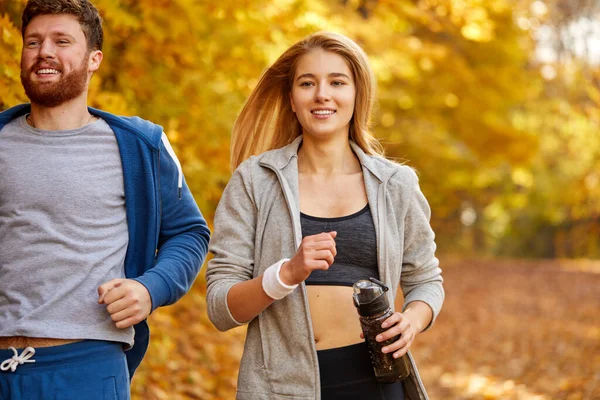 スポーツカップルは森の中をジョギングし — ストック写真