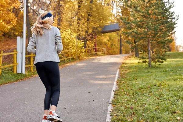 公園内を走るスポーツ女子のリアビュー — ストック写真