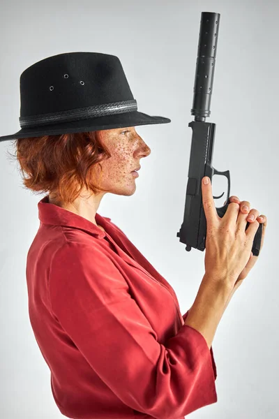 Vista lateral de la hembra posando con arma contra fondo blanco — Foto de Stock