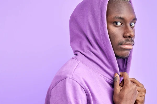 Ruhiger ernster schwarzer Mann in lässigem lila Pullover blickt in die Kamera — Stockfoto