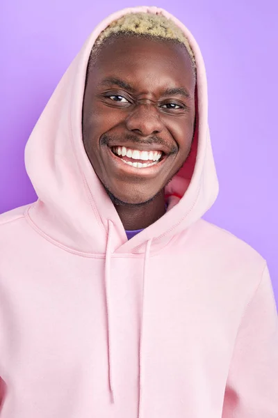 Ritratto di ottimistico ragazzo afro sorridente in pullover rosa alla moda — Foto Stock