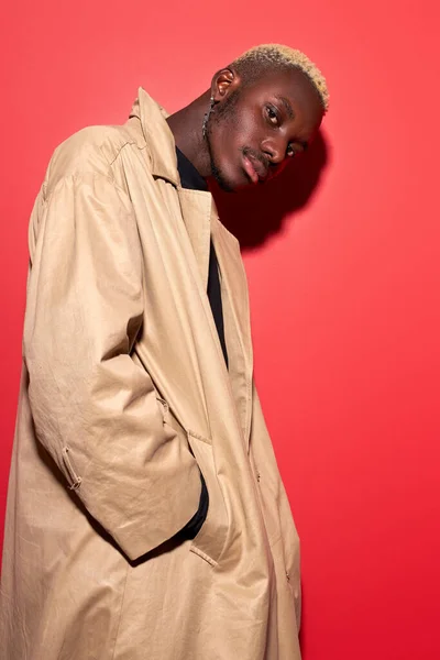 Trendy young african american man in beige trench — Stockfoto