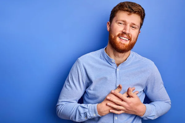 Agradecido caucásico macho está expresando gracias, cogido de la mano en el pecho — Foto de Stock