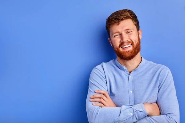 Cheerful caucasian guy in blue stylish shirt smiles at camera isolated — Stockfoto