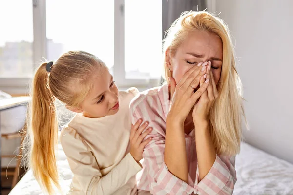 sympathetic kid girl calm down her crying mother