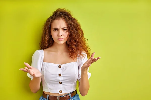 What do you want portrait of confused frustrated girl isolated on green background — Stock Photo, Image