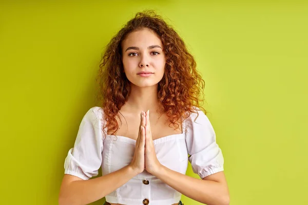 Curly female holding hands in namaste or prayer,meditating — Stock Photo, Image