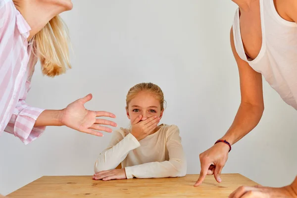 Child girl sit with closed mouth while parent arguing — Stock Photo, Image