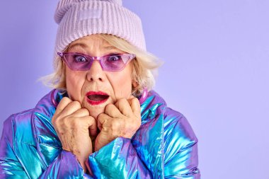 Son sınıftaki kadın üşümüş, sıcak kıyafetler giyiyor.