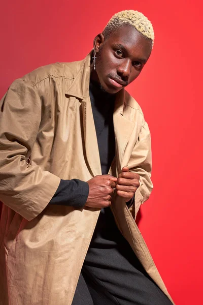 fashion portrait of black man in modern trendy beige trench coat