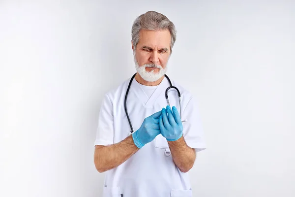 senior male doctor is wearing sterile gloves, preparation