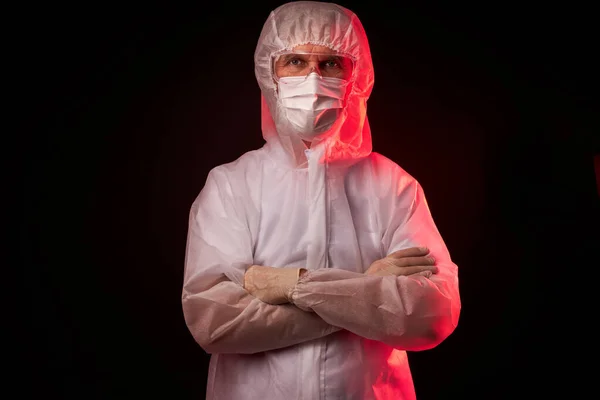 Potret dokter laki-laki dalam setelan medis berpose terisolasi di latar belakang hitam — Stok Foto