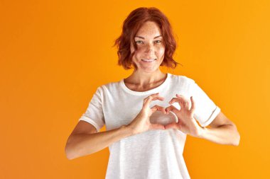 Güzel bir kadın kameraya aşk jesti gösterir