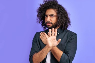 Genç adam avucuyla dur işareti yapıyor.