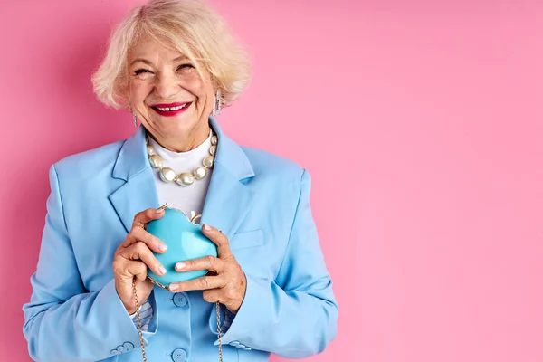 Счастливая жизнерадостная пожилая дама с кошельком в руках — стоковое фото