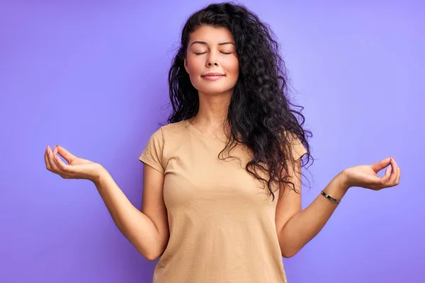 Rustig brunette volwassen vrouw mediteren geïsoleerd in studio — Stockfoto