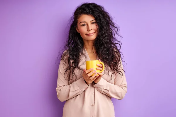 Bella femmina sorridente che tiene in mano una tazza gialla — Foto Stock