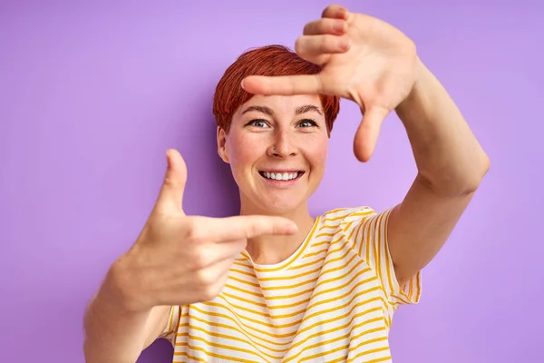 Ruiva mulher adulta segurando a mão em forma de quadrado, fingir tirar foto — Fotografia de Stock