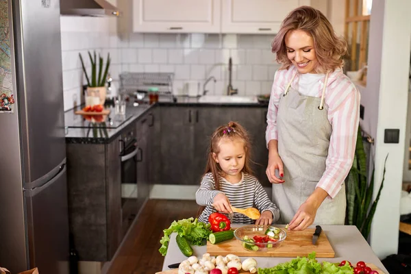 Mãe assiste sua filha fazer progressos na cozinha — Fotografia de Stock