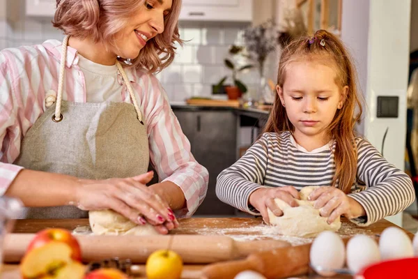 어머니와 딸은 집 부엌에 있는 식탁에서 밀가루로 만든 구운 식품을 준비 한다 — 스톡 사진
