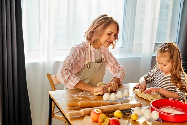 Niña aprendiendo amasar ayudar a mamá adulta en la cocina — Foto de Stock