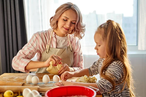 Niña aprendiendo amasar ayudar a mamá adulta en la cocina — Foto de Stock