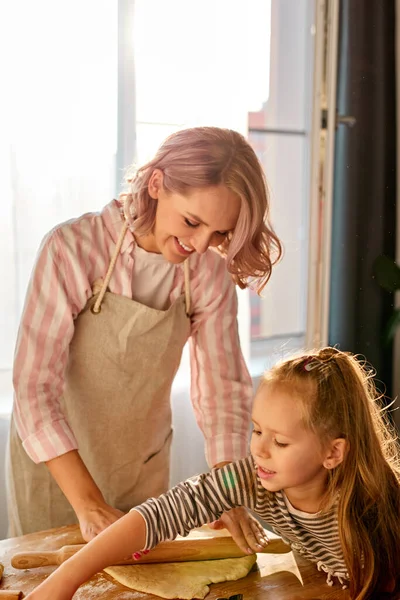 Девушке нравится печь торт с мамой на кухне — стоковое фото