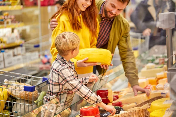 Kaukasische familie met zoon die kaas kiest in de levensmiddelenwinkel — Stockfoto