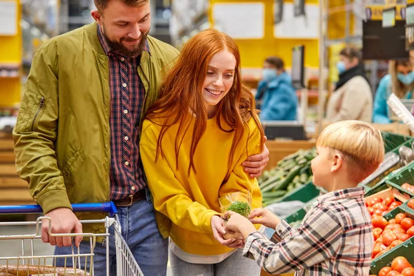 Jonge ouders en kind in supermarkt — Stockfoto