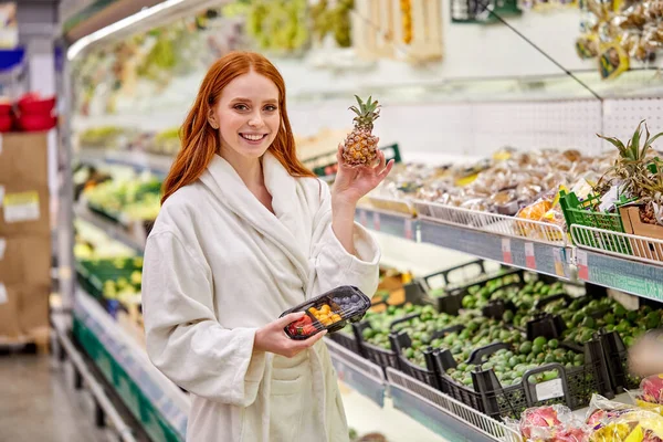 Mulher bonita está escolhendo legumes frescos e frutas na loja — Fotografia de Stock
