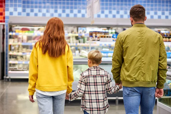 Молодая семья с ребенком, гуляющая в продуктовом магазине — стоковое фото