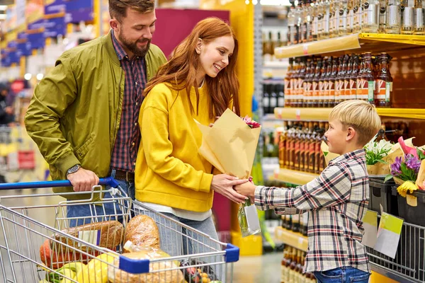 Молодые родители и ребенок в супермаркете — стоковое фото