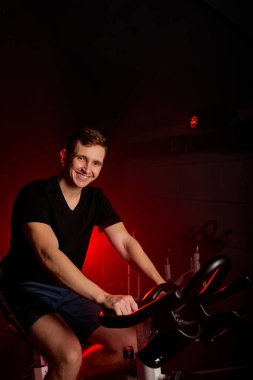 Genç Kafkas fitness adamı spor salonunda bisiklete bindikten sonra dinleniyor.