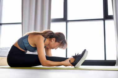 Spor giyimli atletik bir kadın, spor salonunda spor yapıyor. Spor salonunda egzersiz yapıyor.