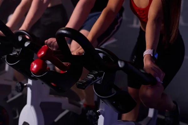 Bicicletas estacionarias fitness personas en un gimnasio club deportivo — Foto de Stock