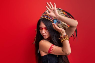 Yaratıcı şaman makyajlı kadın ayinler yapıyor, kollarıyla şamanlık yapıyor.