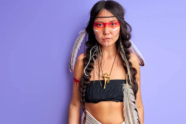 Mujer en indio nativo americano usando y maquillaje colorido posando en la cámara — Foto de Stock